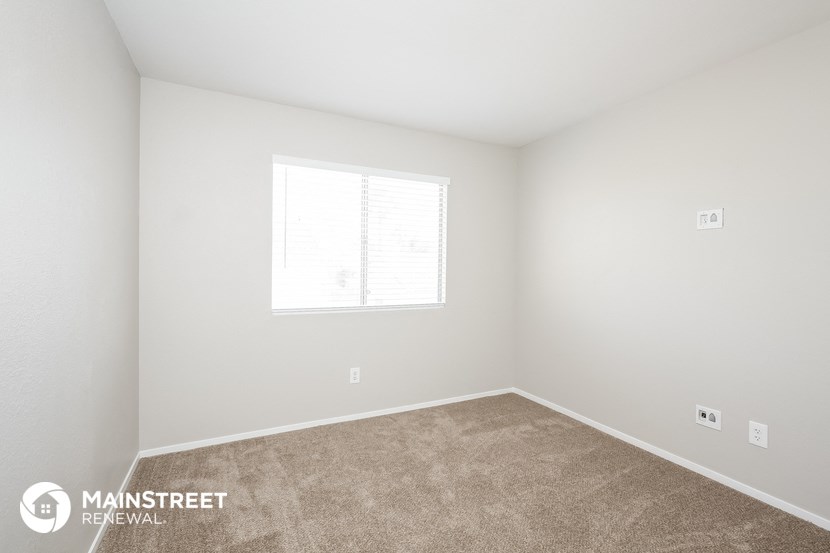 a bedroom with a carpeted floor and a window
