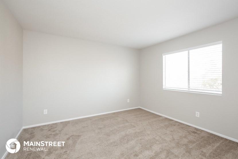 the upstairs bedroom with carpet and window