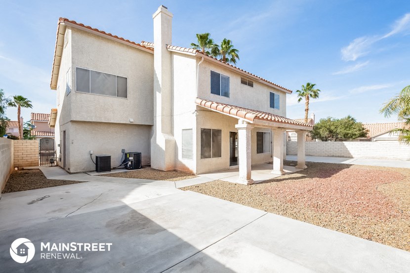 a white house with a driveway and palm trees