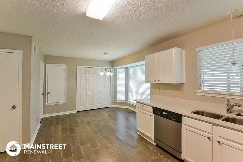a kitchen with white cabinets and stainless steel appliances and a sink
