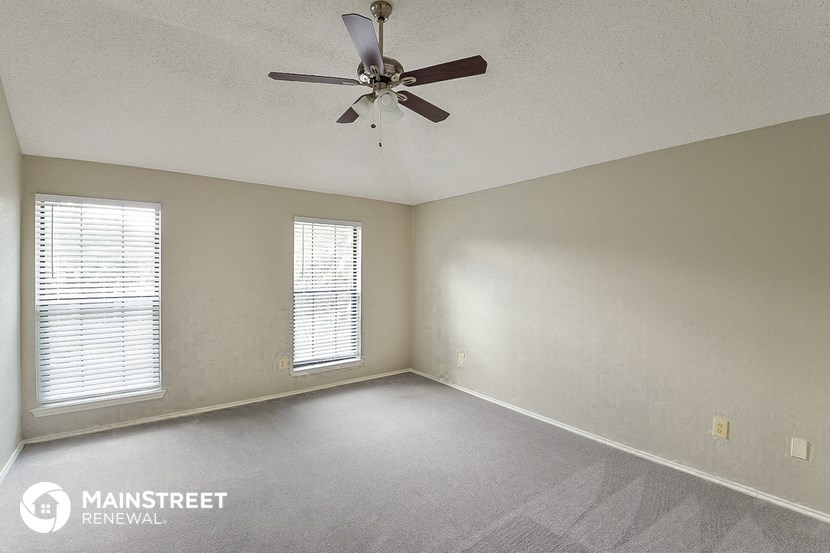 the living room of an empty house with a ceiling fan