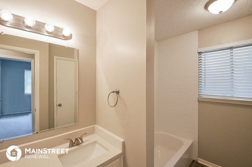 a bathroom with a sink and a mirror and a tub