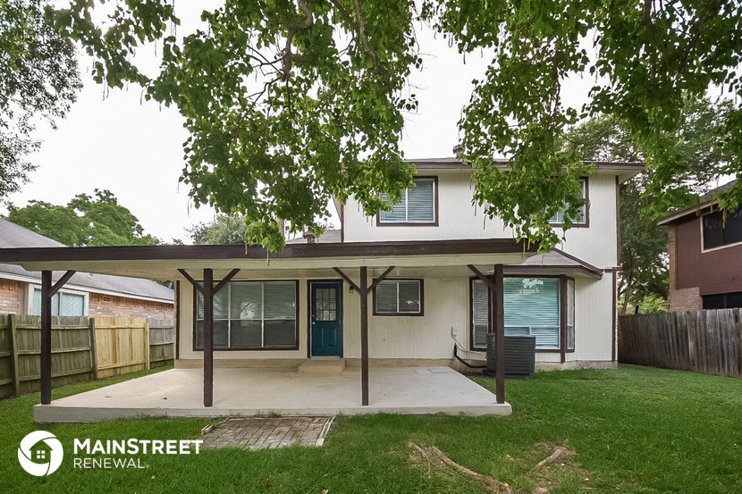 the front of a house with a porch and a tree
