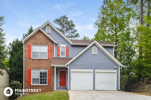 a brick house with a blue siding and a white garage door