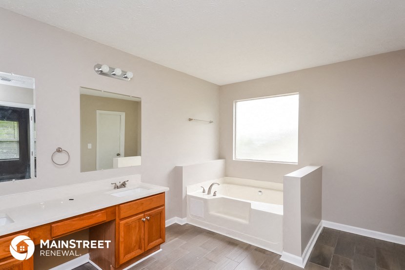 a bathroom with a tub and a sink and a mirror