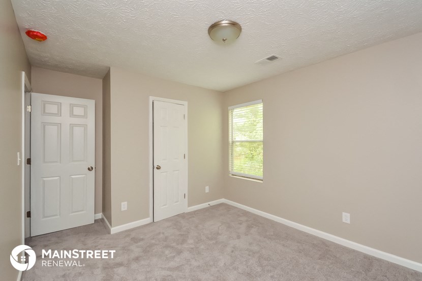 a room with a carpeted floor and a white door