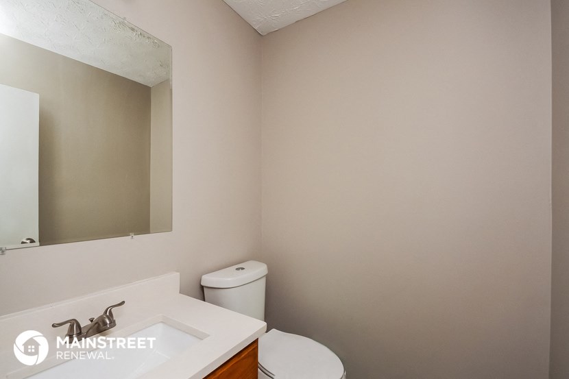 a bathroom with a toilet and a sink and a mirror