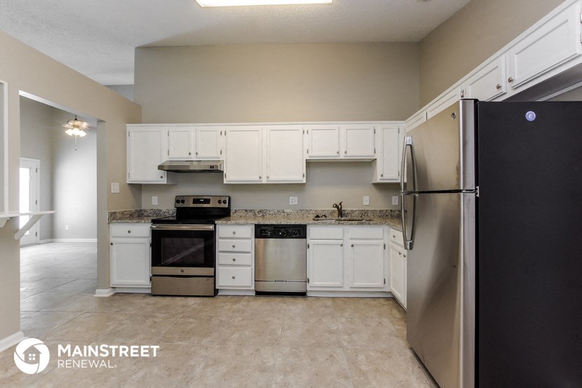 a kitchen with white cabinets and stainless steel appliances