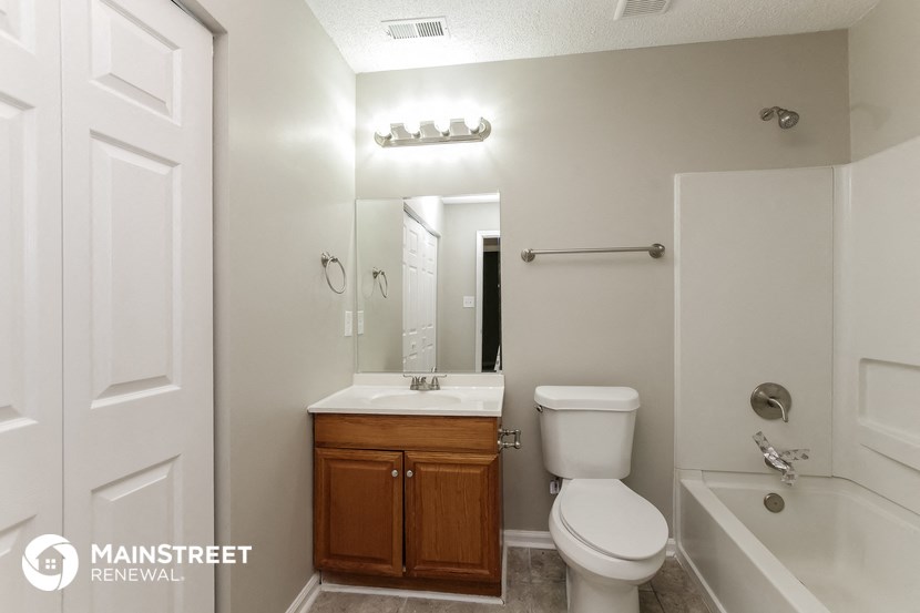 a bathroom with a toilet sink and tub and a mirror