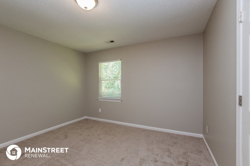 an empty room with carpet and a window