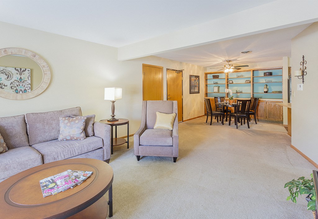 a living room and dining room with a table and chairs