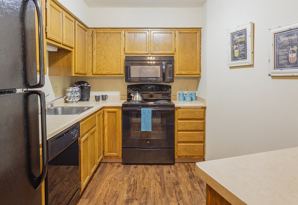 a kitchen with wooden cabinets and a black stove and refrigerator