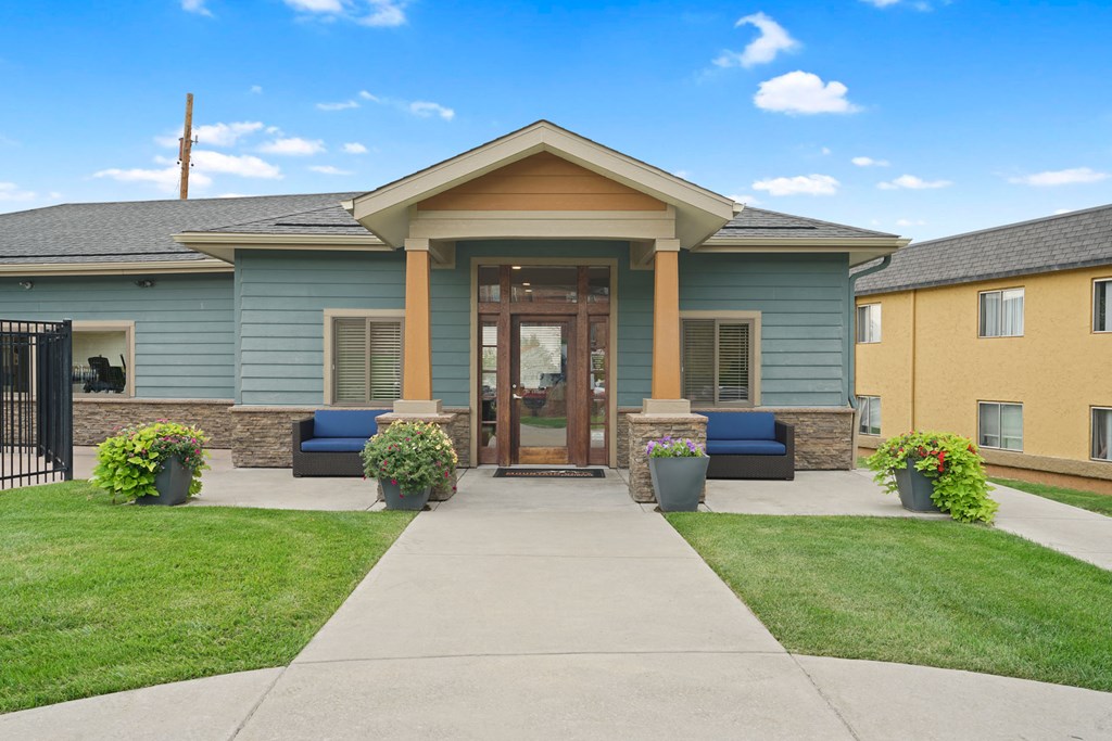 the front of a blue house with a walkway and grass