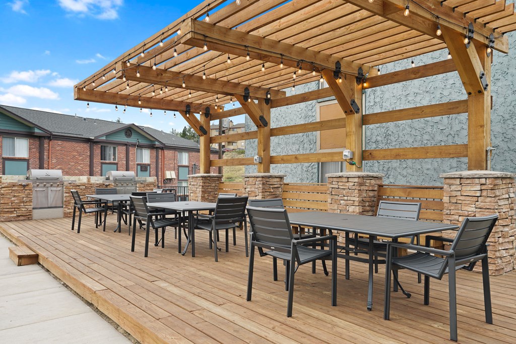 a patio with tables and chairs and a pergola