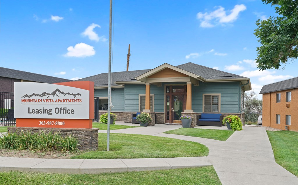a building with a leasing office and a sign in front of it