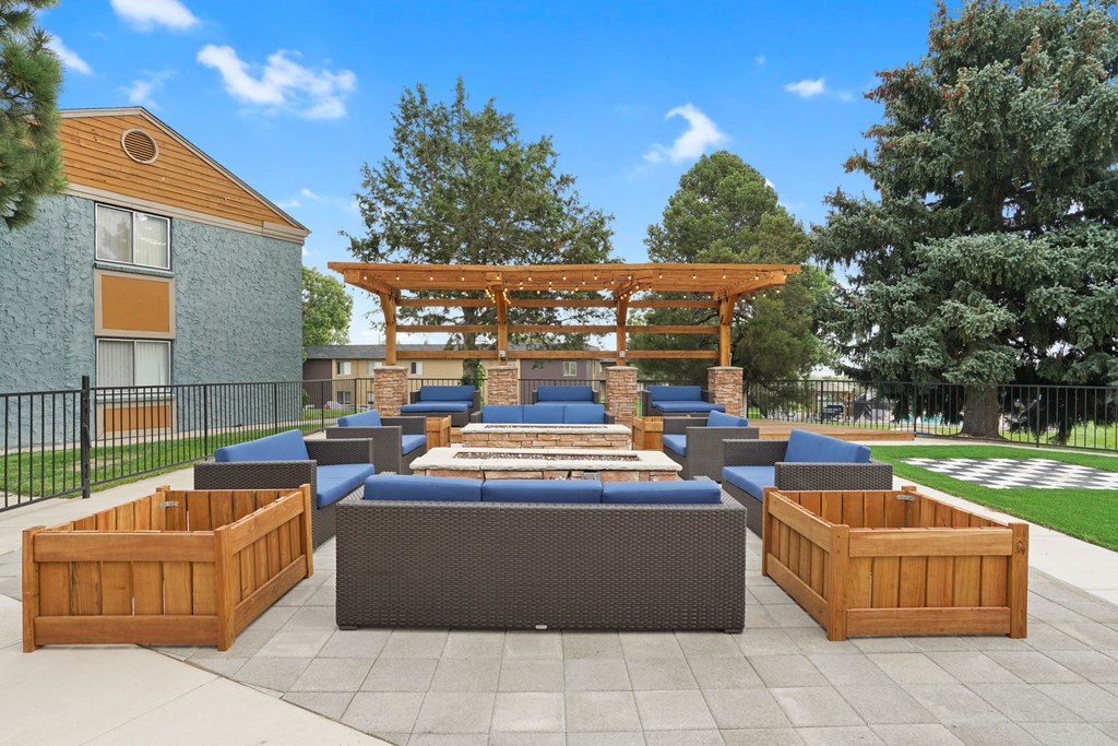 a lounge area with benches and a wooden pavilion with a fire pit
