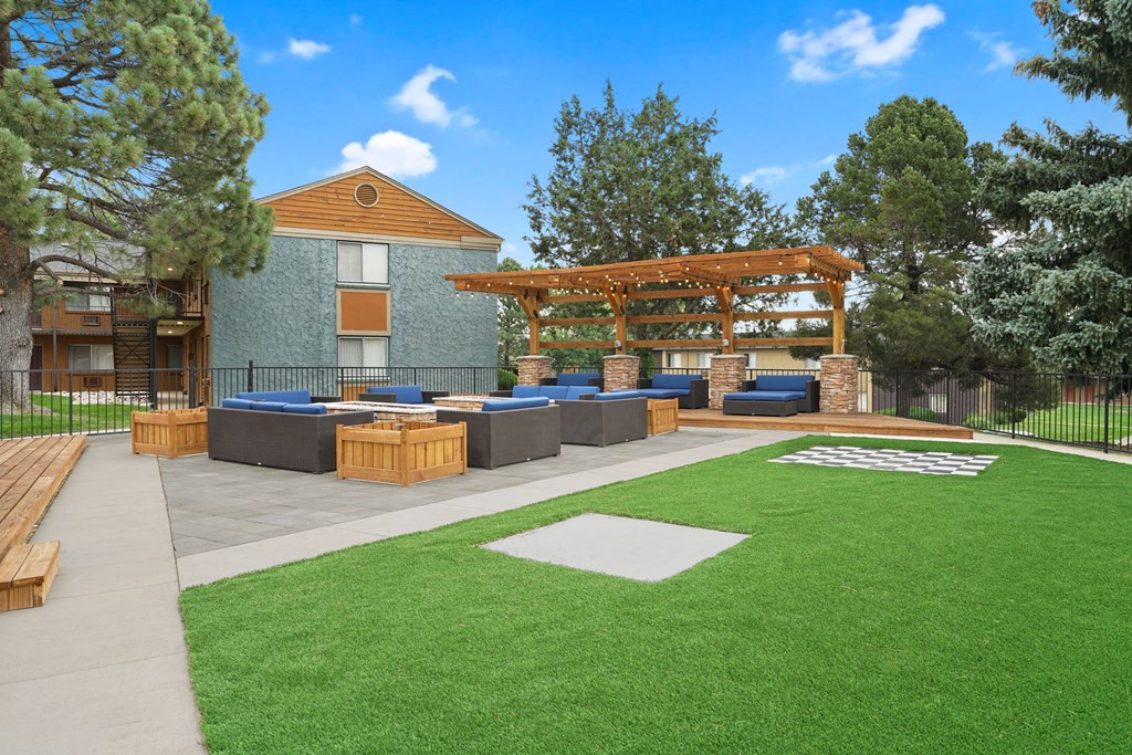 a patio with benches and a pergola in front of a house