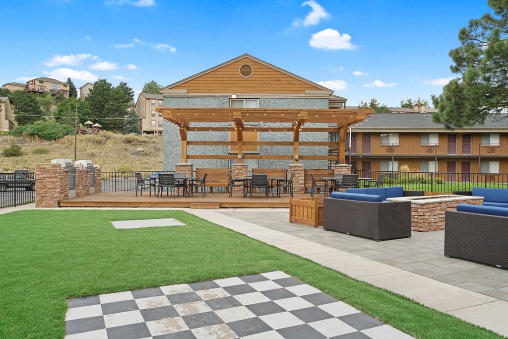 a patio with tables and chairs in front of a building