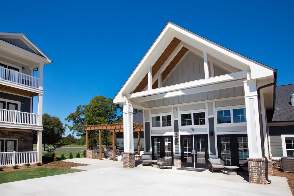 the front of a building with a covered porch and a patio