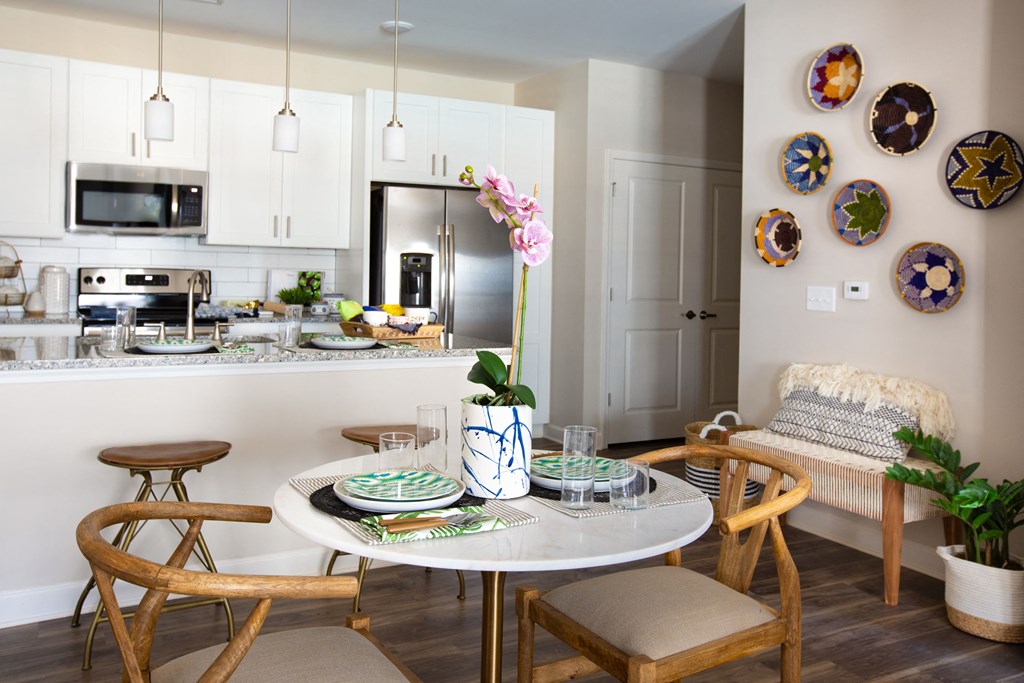 a kitchen and dining area with a table and chairs and a kitchen counter with a