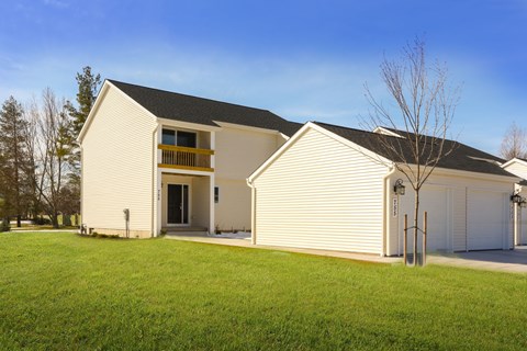 A white house with a black roof and a balcony.