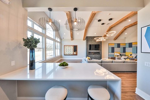 a kitchen with a white counter top and a living room with a fireplace
