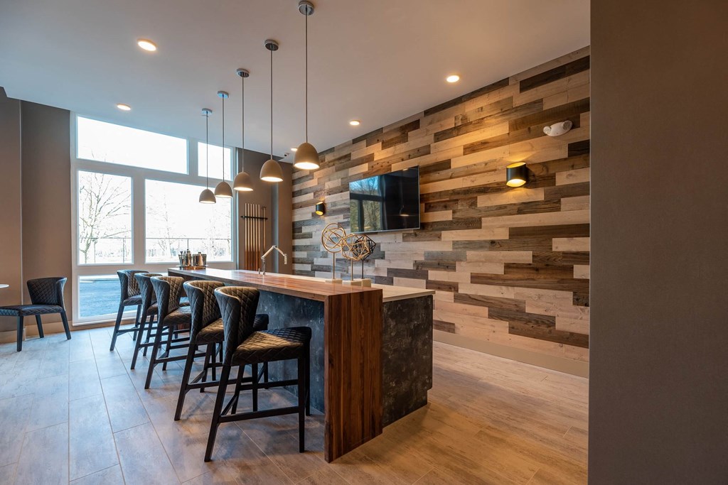 a large kitchen with a bar and chairs and a wood accent wall