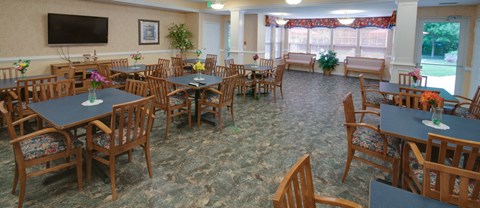a dining room with tables and chairs and a tv
