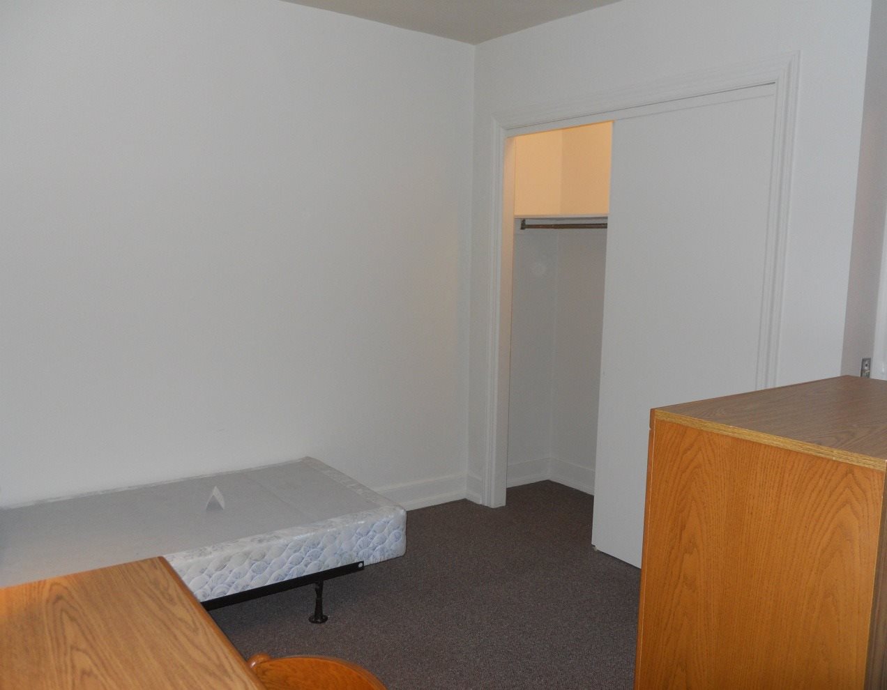 a small bedroom with a bed and a closet