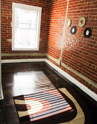 a room with a brick wall and a rug on the floor