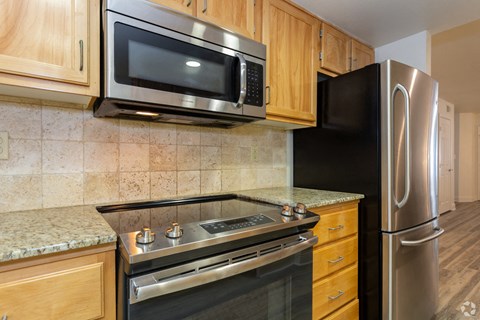 a kitchen with stainless steel appliances and wooden cabinets
