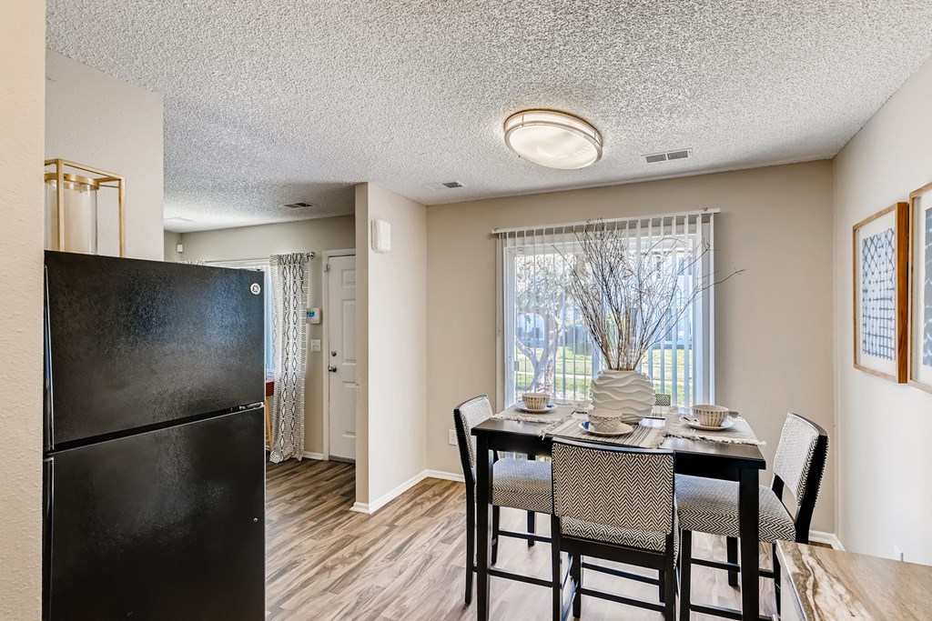 a dining room with a table and chairs and a refrigerator