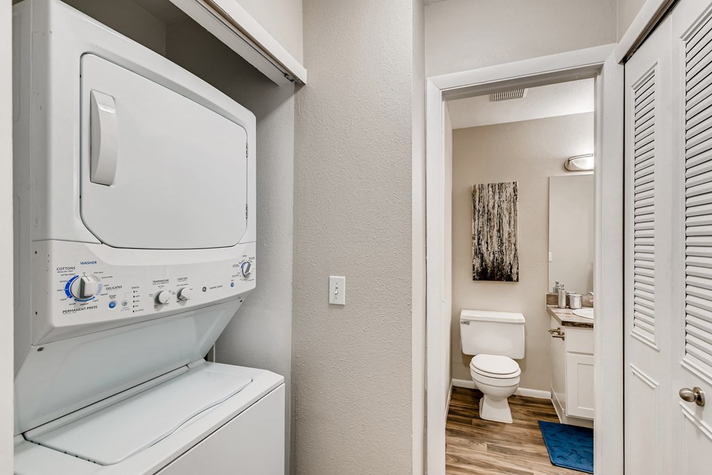 a laundry room with a washer and dryer and a bathroom with a toilet