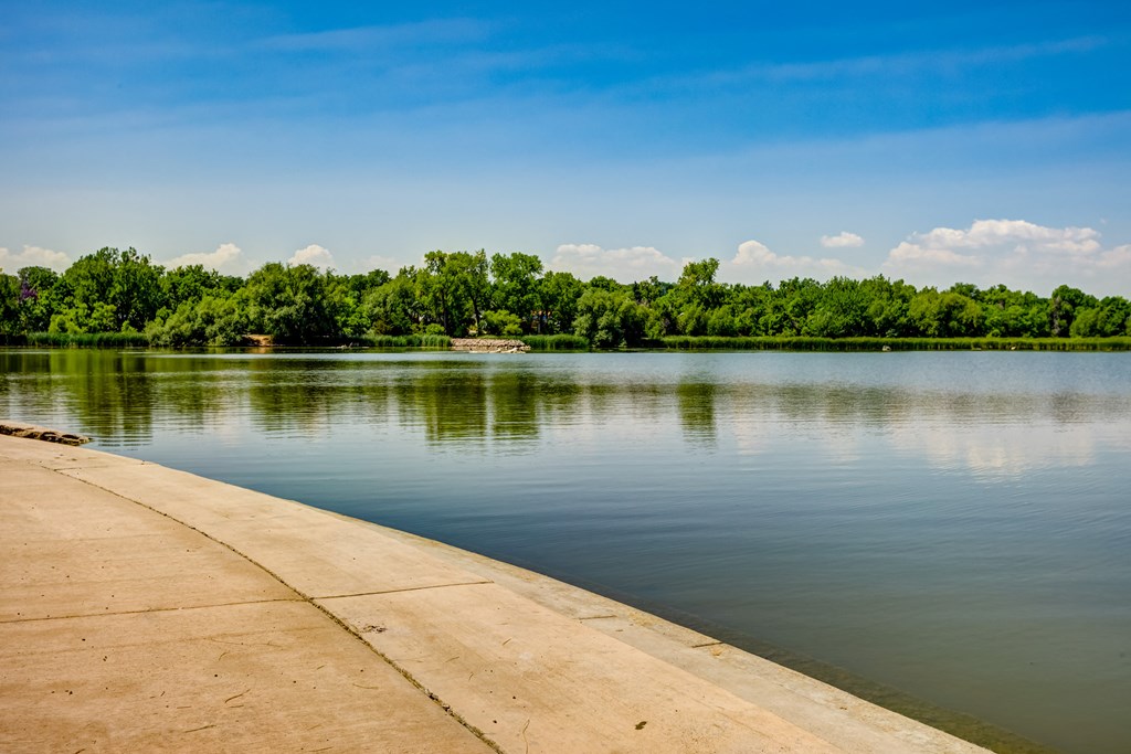 a concrete dock on the water with trees in the background