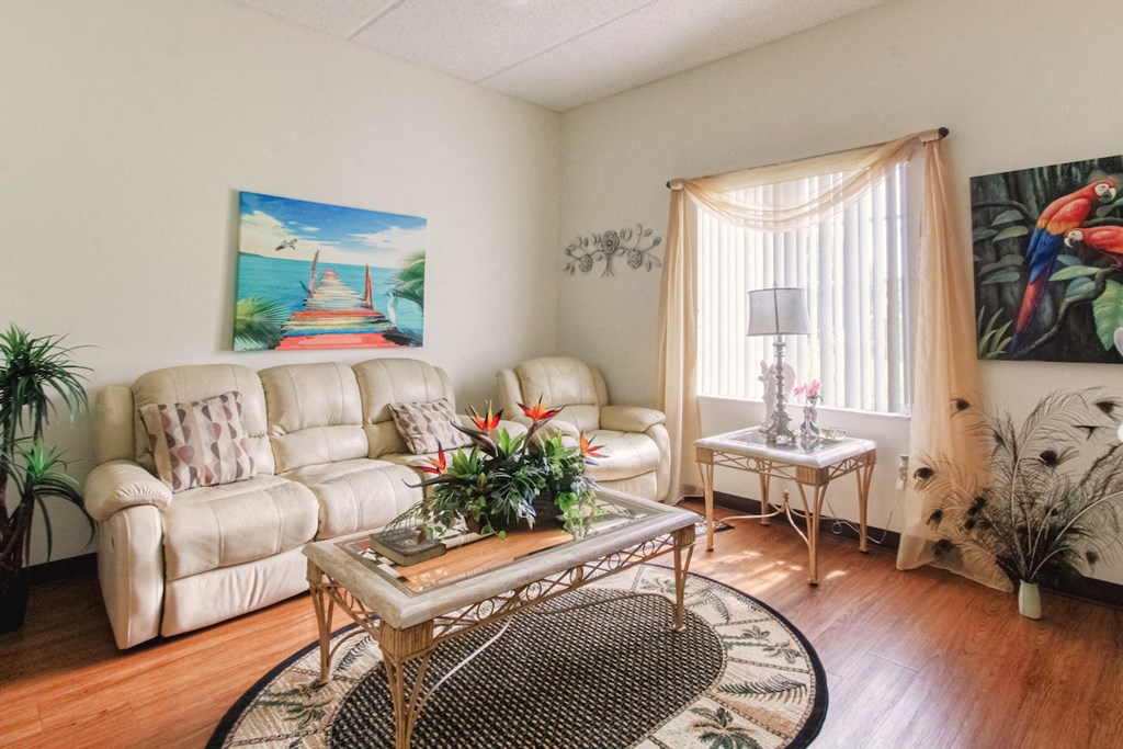 Living room with large window, hardwood-style flooring, and model furnishings