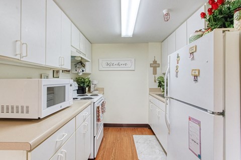 a kitchen with white appliances and white cabinets
