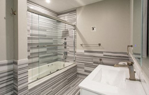 A white sink is in front of a mirror in a bathroom.