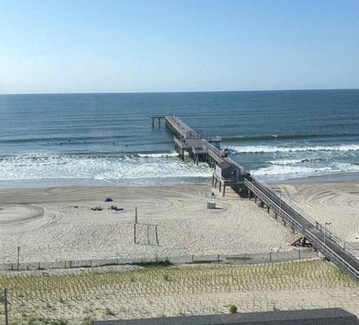 a pier on a beach next to the ocean