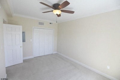 an empty living room with a ceiling fan and a door