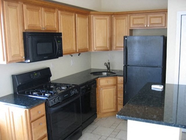 a kitchen with black appliances and wooden cabinets