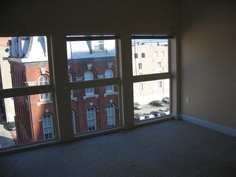 an empty living room with three large windows