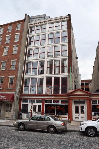 a tall building with cars parked in front of it