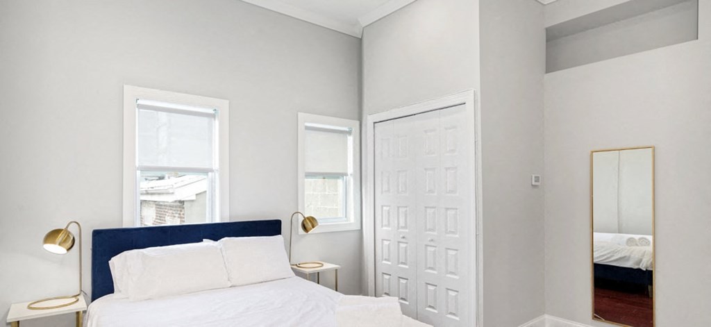 a bedroom with a bed and two windows