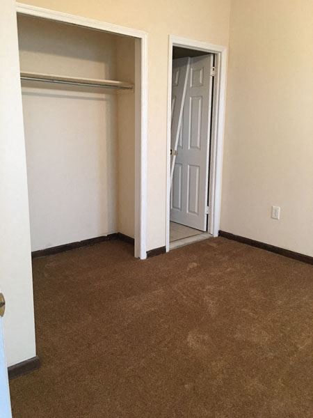 an empty room with a closet and a door