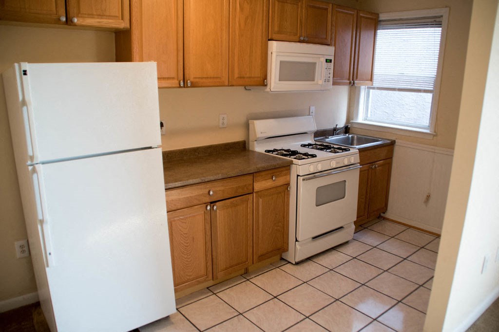 a kitchen with white appliances and wooden cabinets