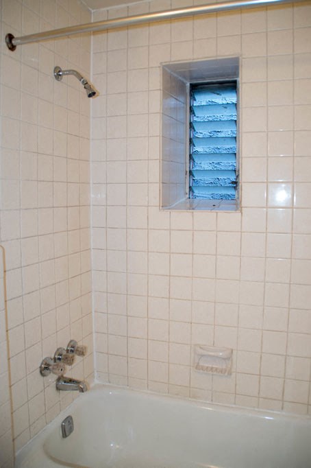 a white bathroom with a tub and a window