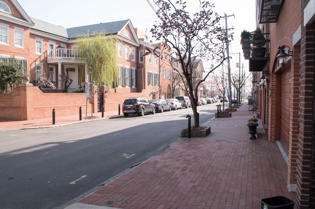 a city street with brick sidewalks and cars parked on the street