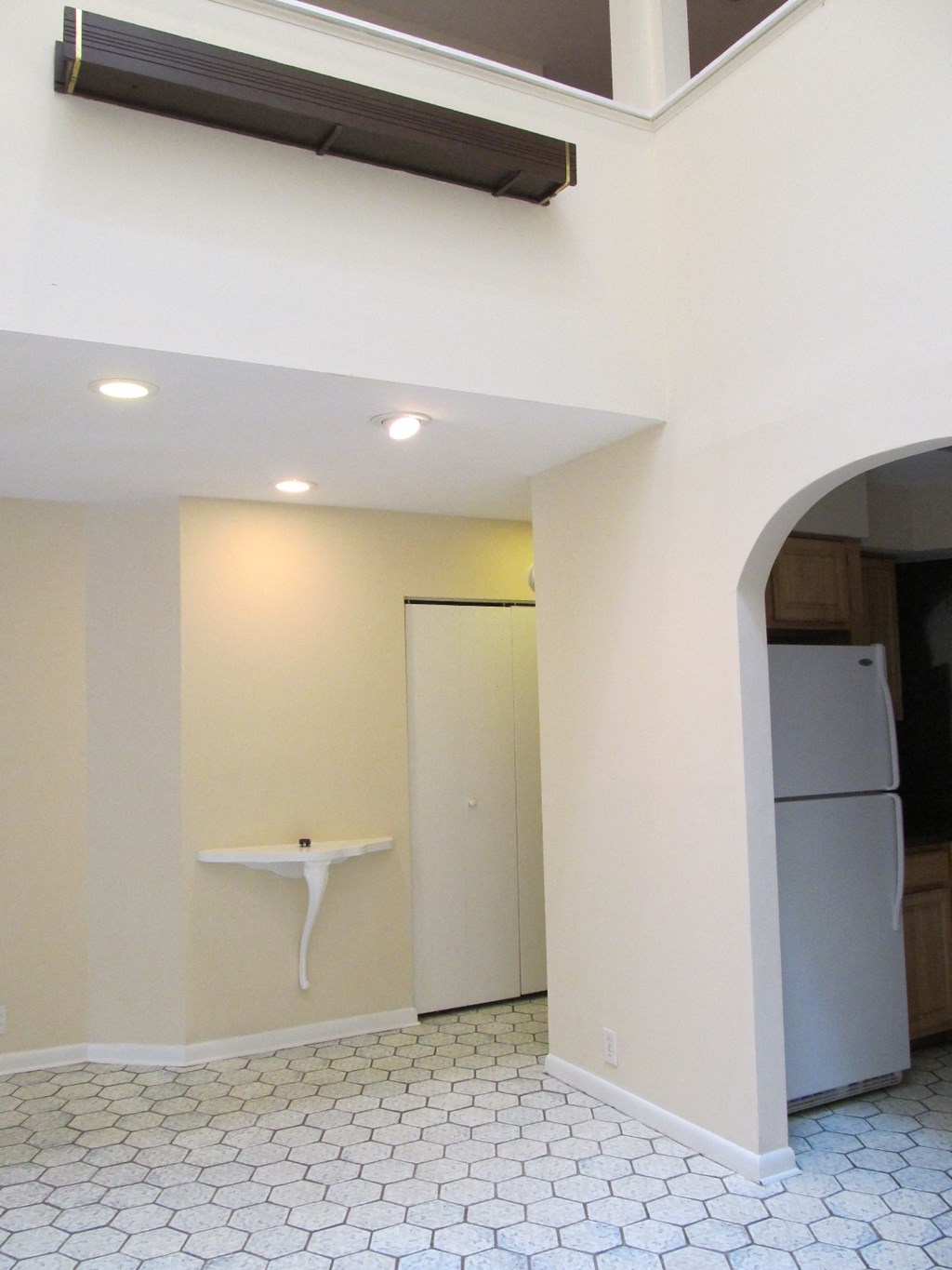 a kitchen with white walls and a refrigerator and a sink