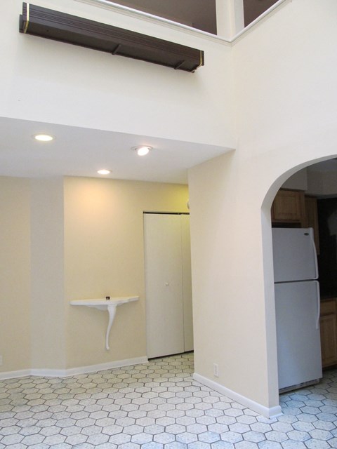 a kitchen with white walls and a refrigerator and a sink