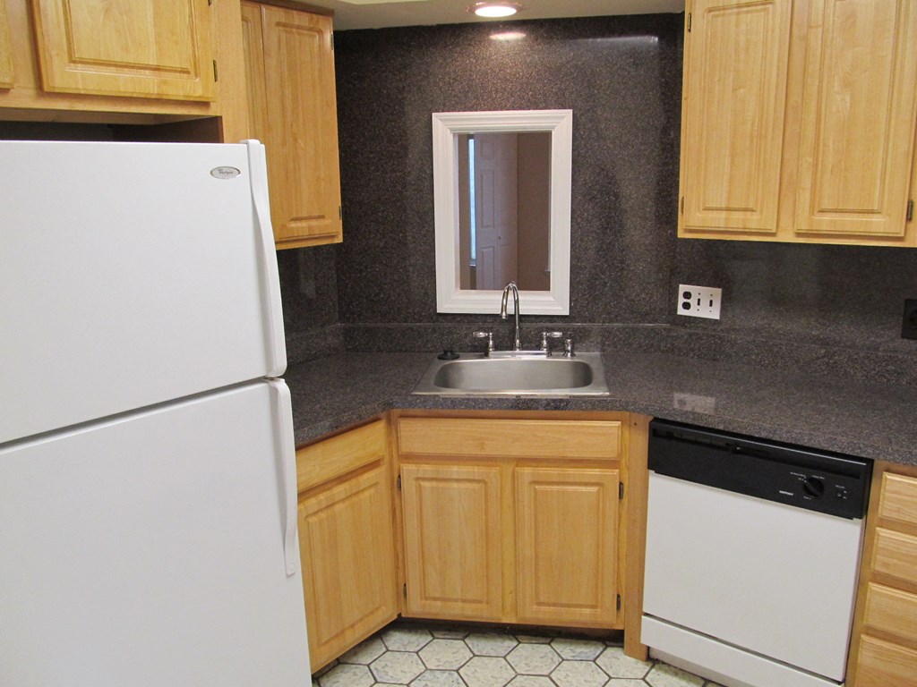 a kitchen with white appliances and wooden cabinets